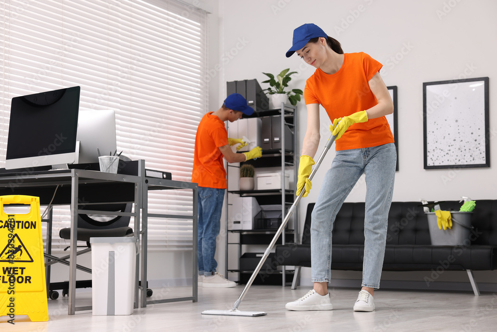 Cleaning service workers cleaning. Bucket with supplies and wet floor sign in office Cleaning service workers cleaning. Bucket with supplies and wet floor sign in office