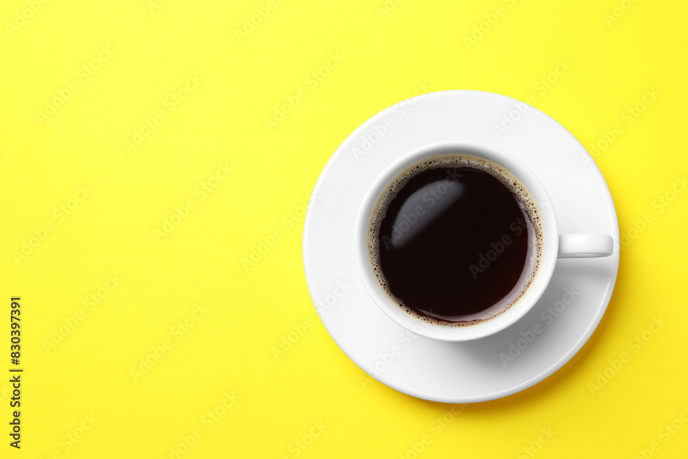 Cup of aromatic coffee on yellow background, top view. Space for text Cup of aromatic coffee on yellow background, top view. Space for text