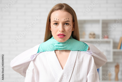 Plastic surgeon holding wom...