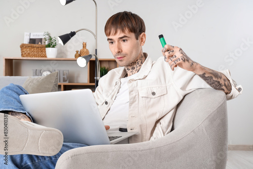 Young man with tattoos usin...