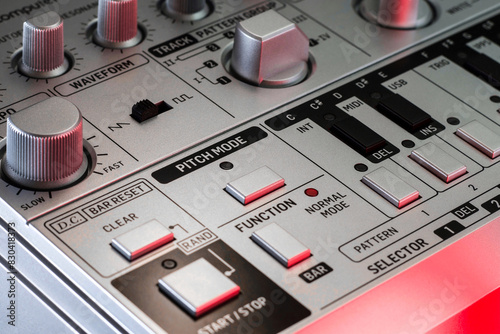 Canvas Print Close-up of silver analog bass synthesizer showing pitch mode, start stop and function and waveform switches