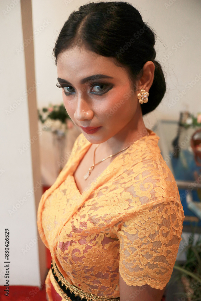 Indonesian woman with beautiful face wearing Kebaya and batik standing Indonesian woman with beautiful face wearing Kebaya and batik standing
