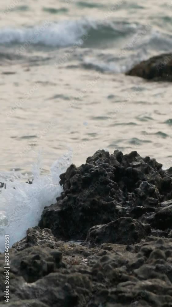 Slow motion vertical video of wave crushing stone on a sea shore. Slow motion vertical video of wave crushing stone on a sea shore.