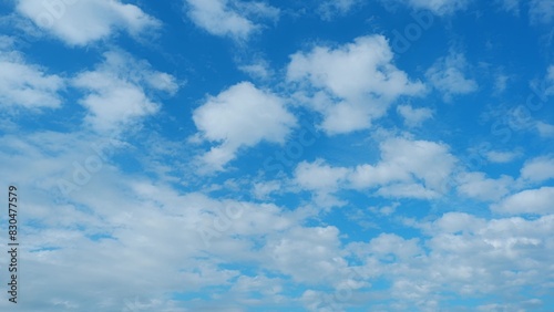 A vibrant blue sky dotted with fluffy white clouds  creating a picturesque and serene atmosphere. The clouds are scattered evenly across the sky  giving a sense of depth and dimension. 