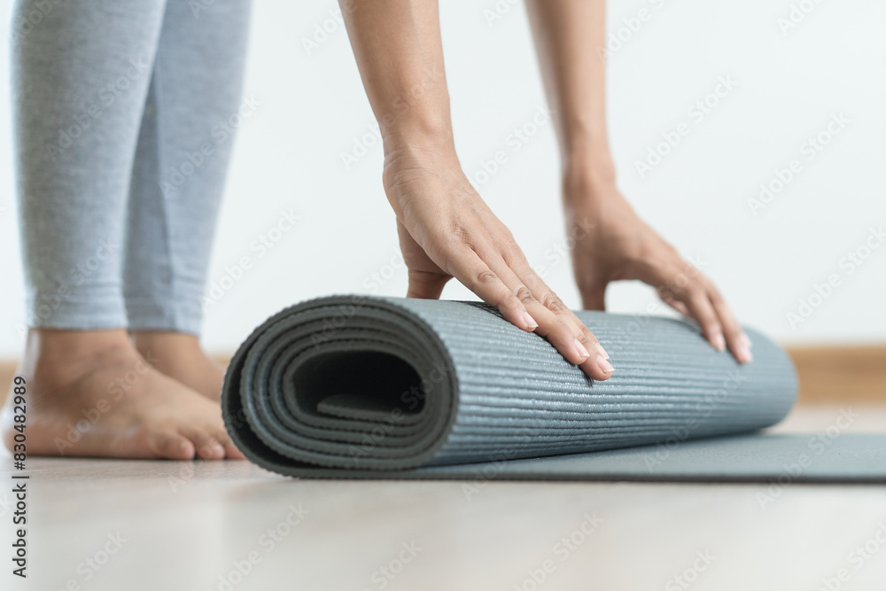 Fototapeta premium Hobby at home concept. woman rolling yoga mat off prepare to exercise in the morning