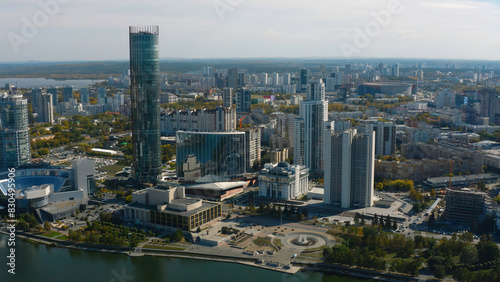 Top view of beautiful city with high-rise buildings in summer. Stock footage. Landscape of modern city from bird's-eye view. Beautiful sunny day in modern city with skyscrapers and river in summer
