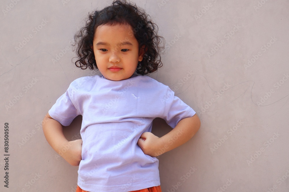 Asian girl is making her hands on her waist while standing looking down. Asian girl is making her hands on her waist while standing looking down.