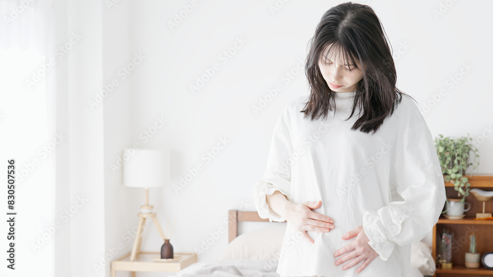 ぽっこりお腹を気にする女性 ぽっこりお腹を気にする女性