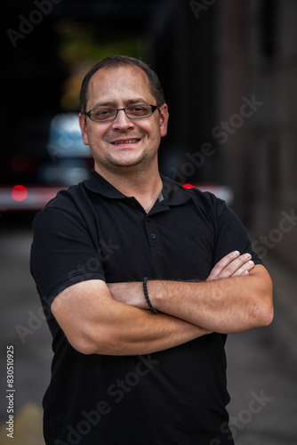 A successful businessman with crossed arms, posing outdoors
