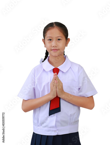 Asian girl student in primary or elementary school uniform standing with Pay respect or pray posture isolated on white background. Image front view with clipping path. photo