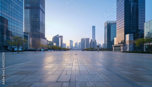 Empty urban plaza with towering skyscrapers in the background. The morning sun casts a golden glow on the pavement.