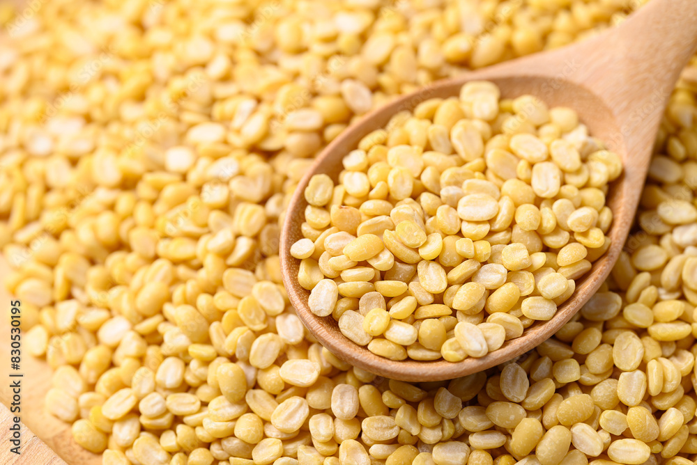 Yellow peeled split mung bean in wooden spoon, Food ingredient Yellow peeled split mung bean in wooden spoon, Food ingredient