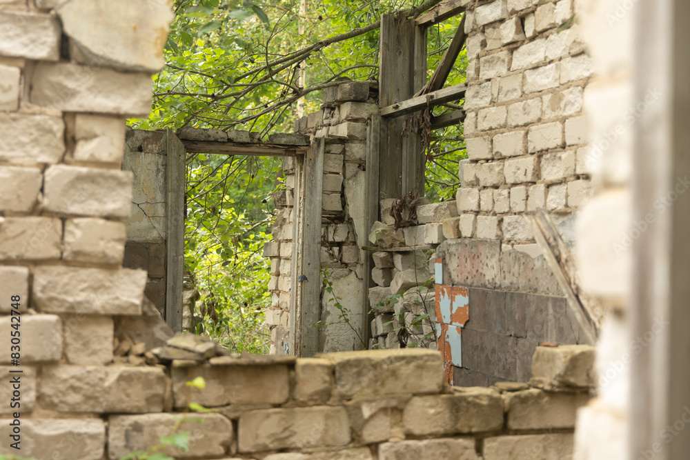 A broken, empty window of building ruins from Soviet times. Collapsed brick wall with window. Latvia, Europe. A broken, empty window of building ruins from Soviet times. Collapsed brick wall with window. Latvia, Europe.