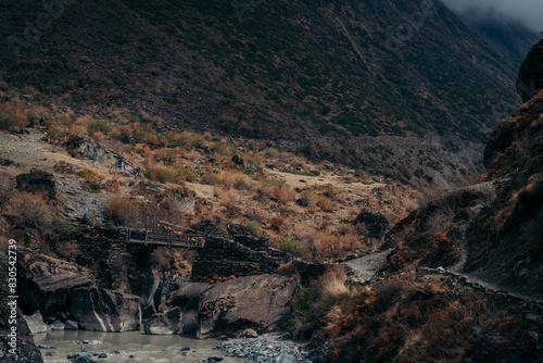 Old bridge crossing a river in Tsum Valley, Nepal photo