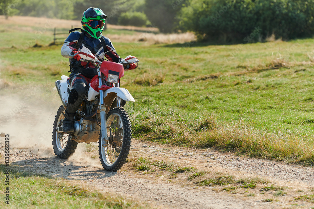 A professional motocross rider exhilaratingly riding a treacherous off-road forest trail on their motorcycle. A professional motocross rider exhilaratingly riding a treacherous off-road forest trail on their motorcycle.