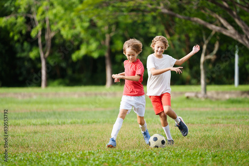 Child playing football. Kids play soccer. © famveldman