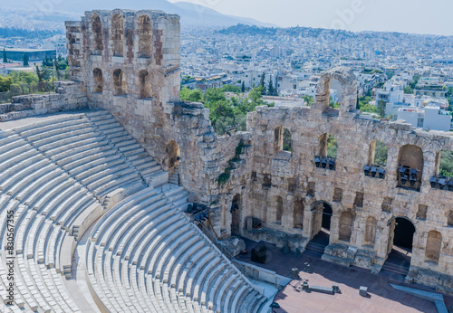Ancient theater ruins with the city skyline in the background, showing old stone structures, in Athens, Greece photo