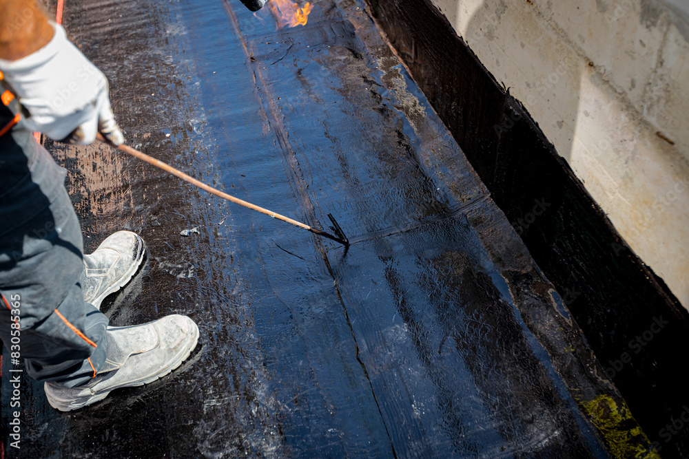 Obraz premium Worker using a gas burner, propane blowtorch to melt and arrange resin