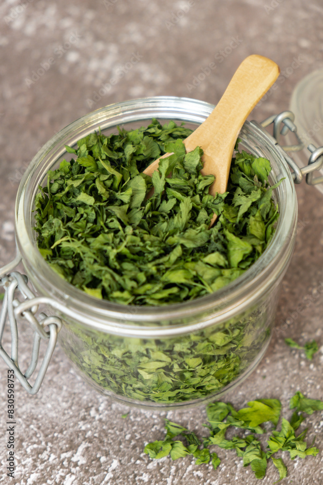 Dry parsley spice with wooden spoon in glass jar. Homegrown herbs and spices for cooking. Fresh dried aromatic natural food ingredients. Copy space Dry parsley spice with wooden spoon in glass jar. Homegrown herbs and spices for cooking. Fresh dried aromatic natural food ingredients. Copy space