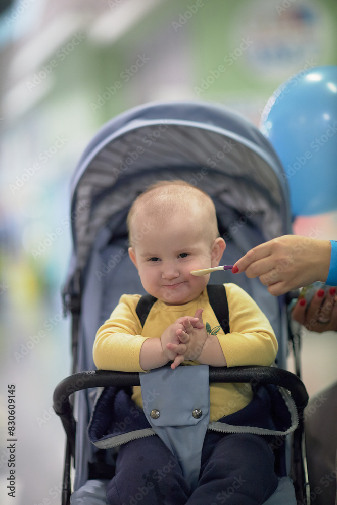 a one-year-old child, a boy, eats on the road, has a snack on the way in a stroller a one-year-old child, a boy, eats on the road, has a snack on the way in a stroller
