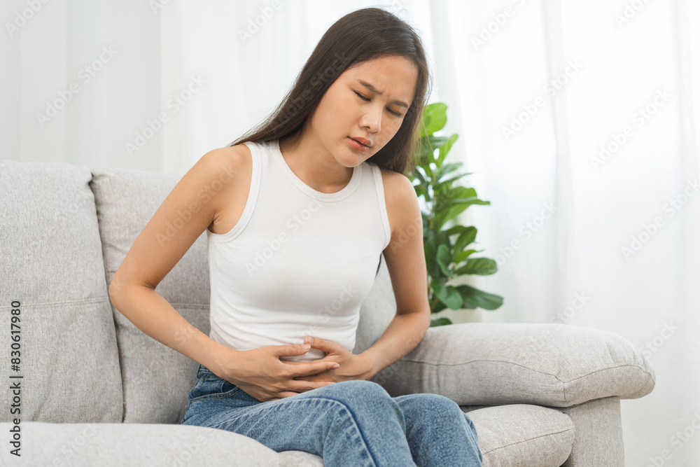 Flatulence asian young woman, girl hand in stomach ache, suffer from food poisoning, abdominal pain and colon problem, gastritis or diarrhoea. Patient belly, abdomen or inflammation, concept. Flatulence asian young woman, girl hand in stomach ache, suffer from food poisoning, abdominal pain and colon problem, gastritis or diarrhoea. Patient belly, abdomen or inflammation, concept.