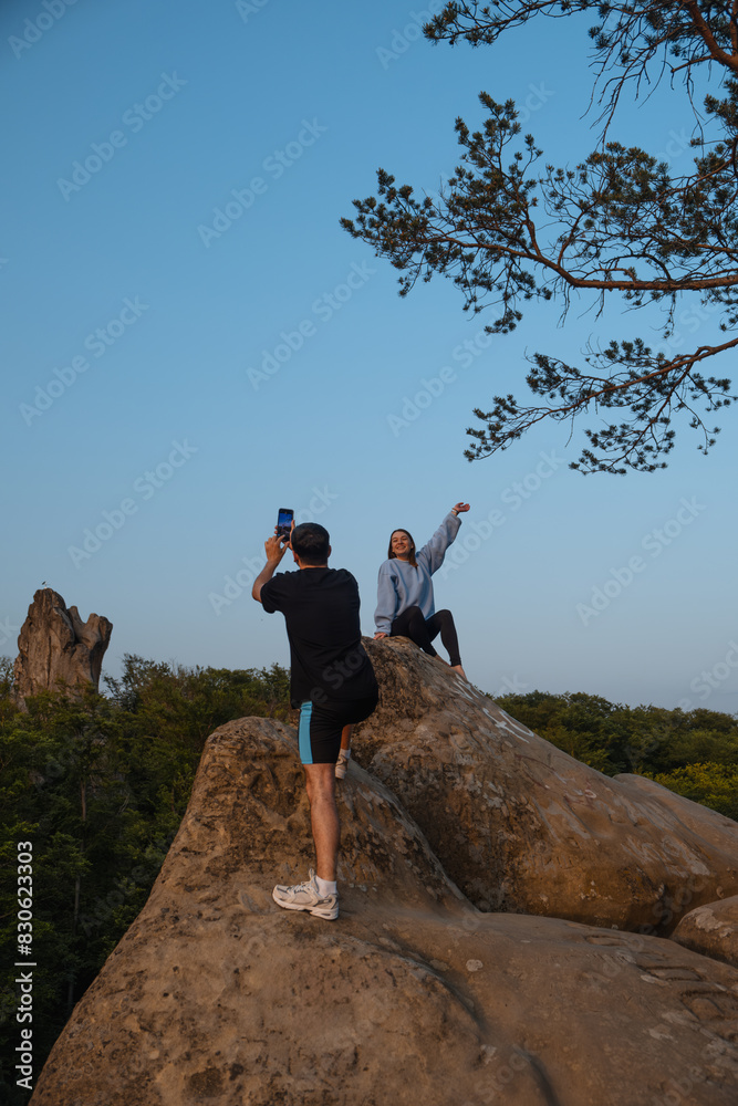 Fototapeta premium happy couple having date at the cliff on sunset