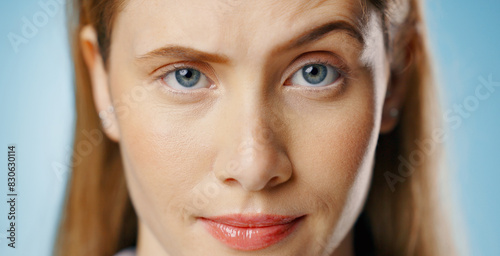 Portrait, smirk and surprise with woman, doubt and girl with raise eyebrow on blue studio background. Face, person or girl with emotion, truth or confused with facial expression, shocked or suspicion photo