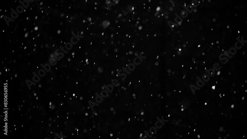 Snow on black background, slow motion, falling snowflakes, snowing, natural snowfall backdrop for overlay effect.

