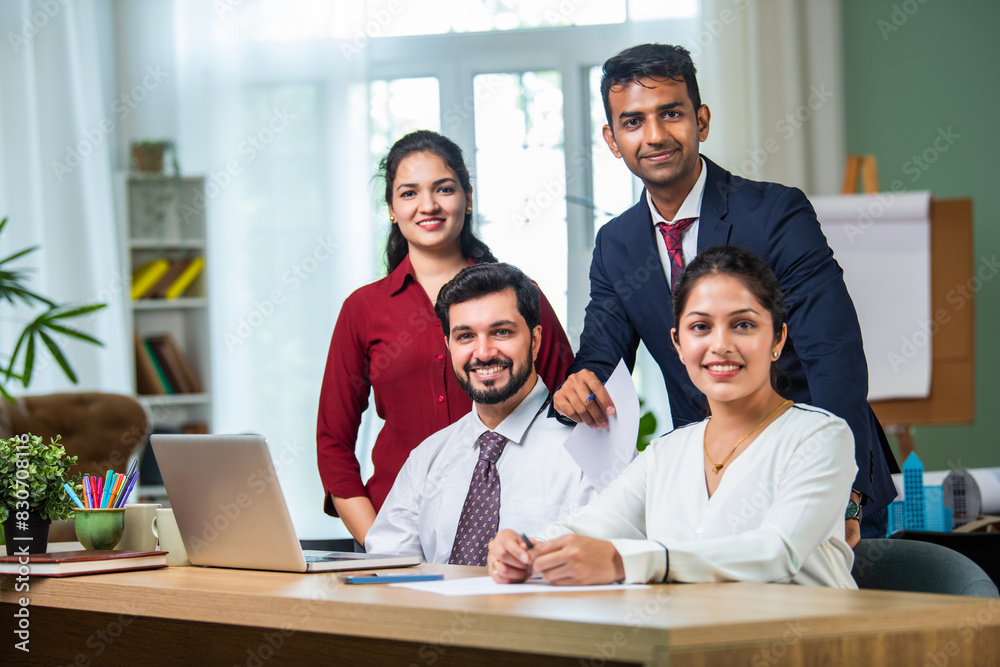 Indian young businesspeople using laptop in group meeting at desk Indian young businesspeople using laptop in group meeting at desk