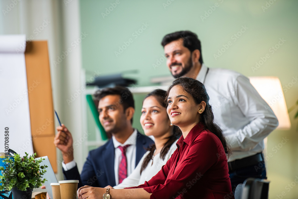 Indian young businesspeople using laptop in group meeting at desk Indian young businesspeople using laptop in group meeting at desk