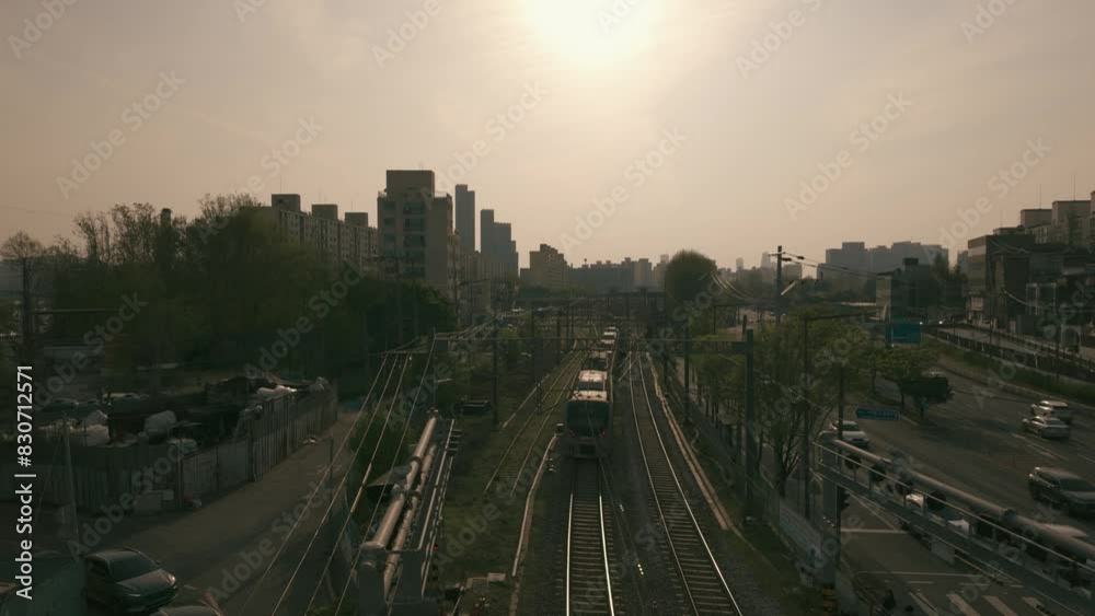 Experience the captivating scene of a train swiftly passing by at dawn, filmed at a station adjacent to a highway, where the early morning. Experience the captivating scene of a train swiftly passing by at dawn, filmed at a station adjacent to a highway, where the early morning.