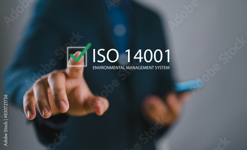 ISO 14001 concept. Identify, control and reduce the environmental impact of activities. Businessman choose ISO 14001 certified on virtual screen for environmental management systems (EMS)