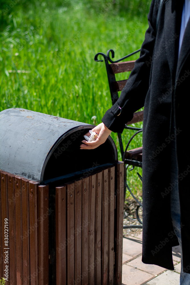 Young woman throwing trash in the trash can. World Environment Day concept. High quality photo Young woman throwing trash in the trash can. World Environment Day concept. High quality photo