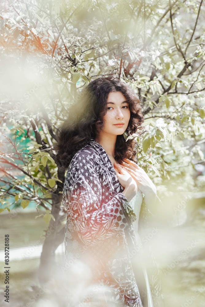 Woman in spring garden in chapan in Central Asia Woman in spring garden in chapan in Central Asia