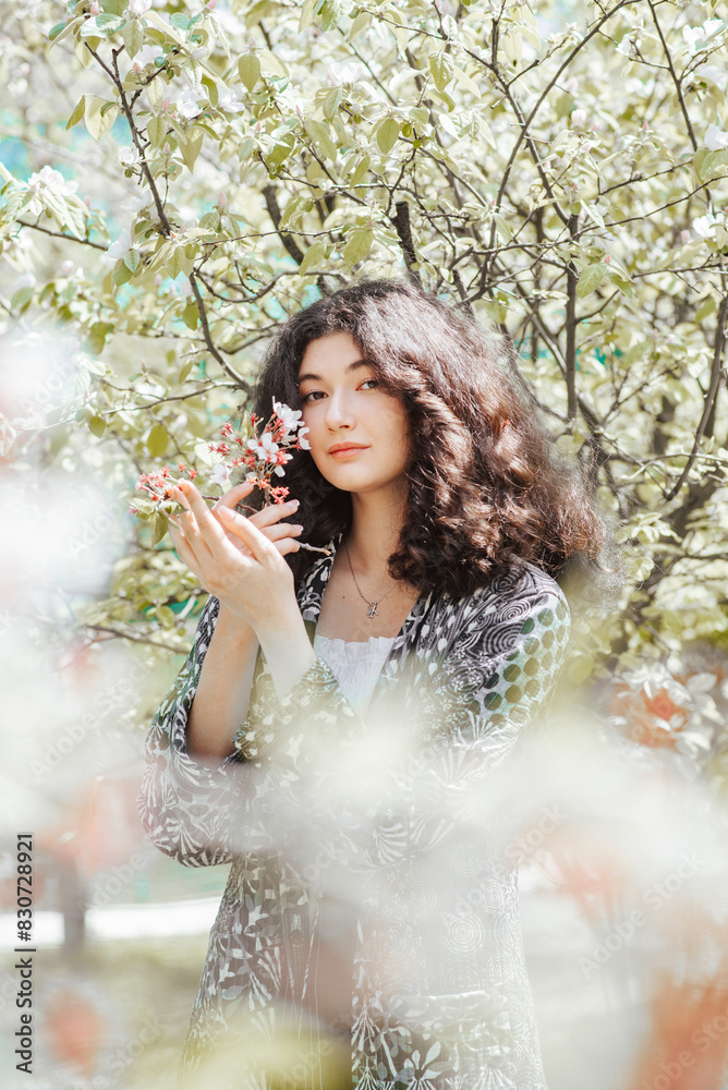 Woman in spring garden in chapan in Central Asia Woman in spring garden in chapan in Central Asia