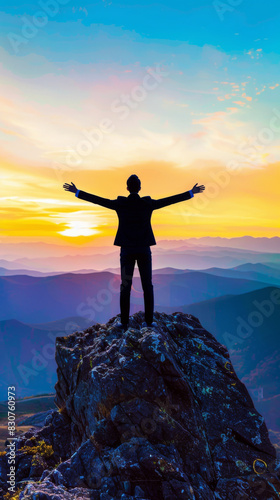 Silhouette of Person with Arms Outstretched on Mountain Top at Sunset © artem