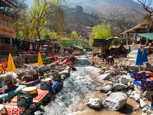Riverside tables and eating spaces at colourful waterside restaurants in the Ourika Valley in the foothills of the Atlas Mountains in Morocco, North Africa.  photo