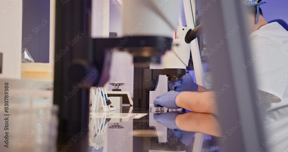 Embryologist performs artificial fertilization of human egg in a laboratory setting, showcasing advanced reproductive science techniques.