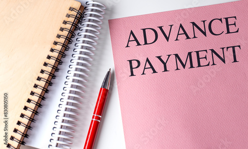 ADVANCE PAYMENT text on pink paper with notebooks