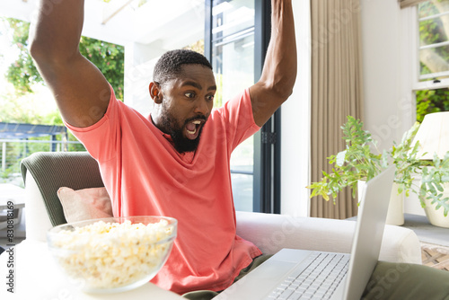 African American man celebrating in front of laptop at home photo