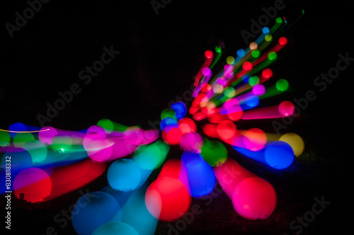 Light painting abstract background. Colorful light balls, long exposure. Abstract butterfly against a black background. Zoom burst effect.