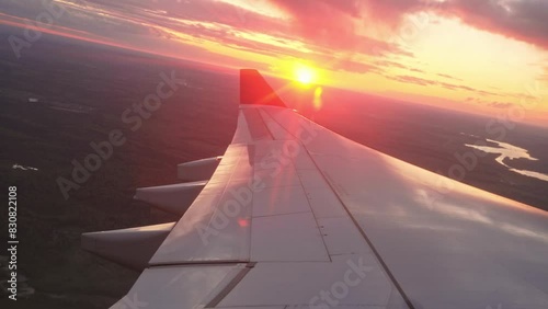 Passenger air plane fly high above sky. View from aircraft porthole. Comfortable fast airplane travel. Aviation concept. Airliner flight beautiful sunset. Fun summer journey. Wing of jet from window.