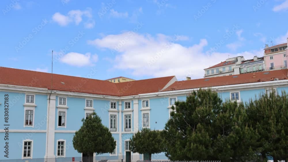 Time lapse, light blue and peach buildings with green pine trees on a sunny day Time lapse, light blue and peach buildings with green pine trees on a sunny day