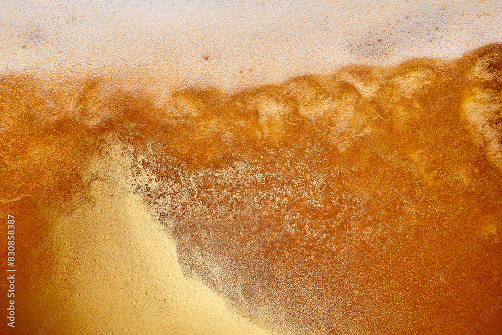 Textured photo. Close-up of pouring foamy beer into glass. Light beer and has thick, creamy head of foam. Abstract background. Concept of refreshing alcohol drink, Oktoberfest, summer, party Textured photo. Close-up of pouring foamy beer into glass. Light beer and has thick, creamy head of foam. Abstract background. Concept of refreshing alcohol drink, Oktoberfest, summer, party