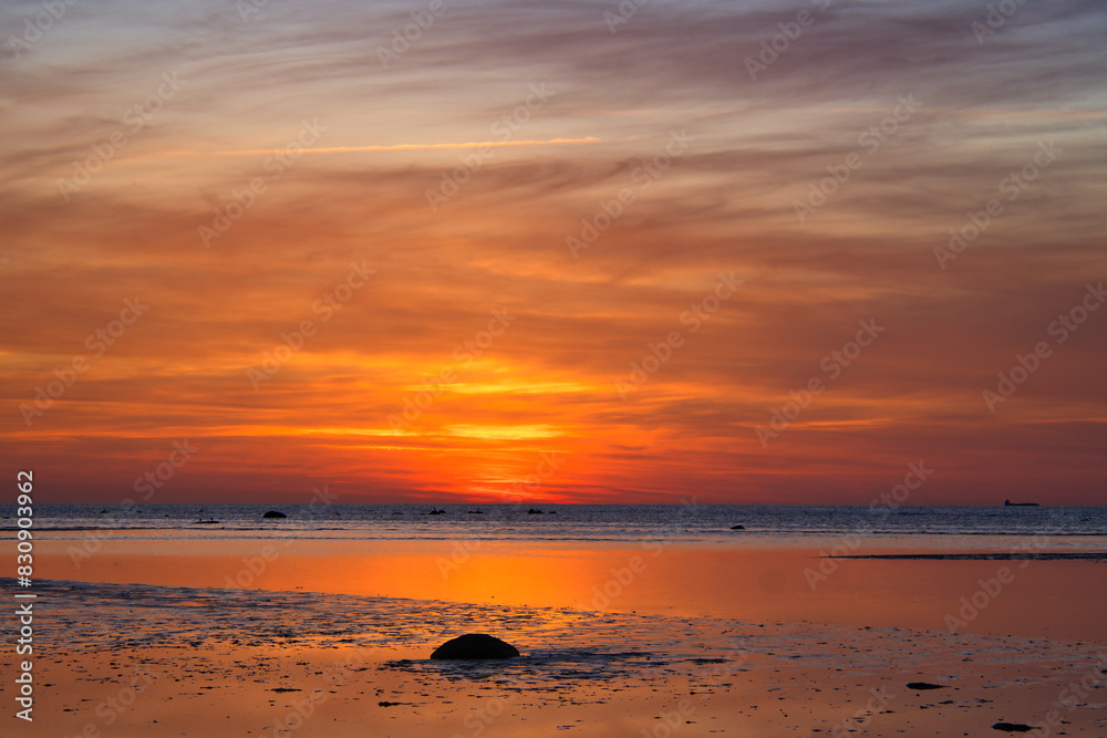 Obraz premium Sunset, illuminated sea. Sandy beach in the foreground. Light waves. Poel island