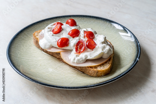 Delicious sandwich with burrata cheese, ham and cherry tomatoes.