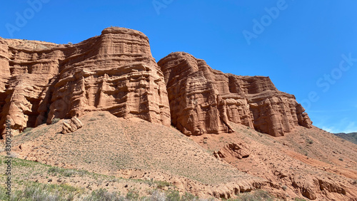 The famous Konorchek canyons in Kyrgyzstan. A rocky red mountain against a clear blue sky. Weekend trekking