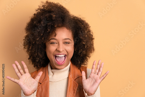 fun afro brazilian woman raising arms and celebrating in studio shot. portrait, real people concept. photo