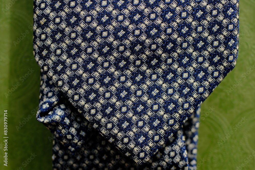Classic tie fabric texture close-up with abstract pattern on a green background Classic tie fabric texture close-up with abstract pattern on a green background