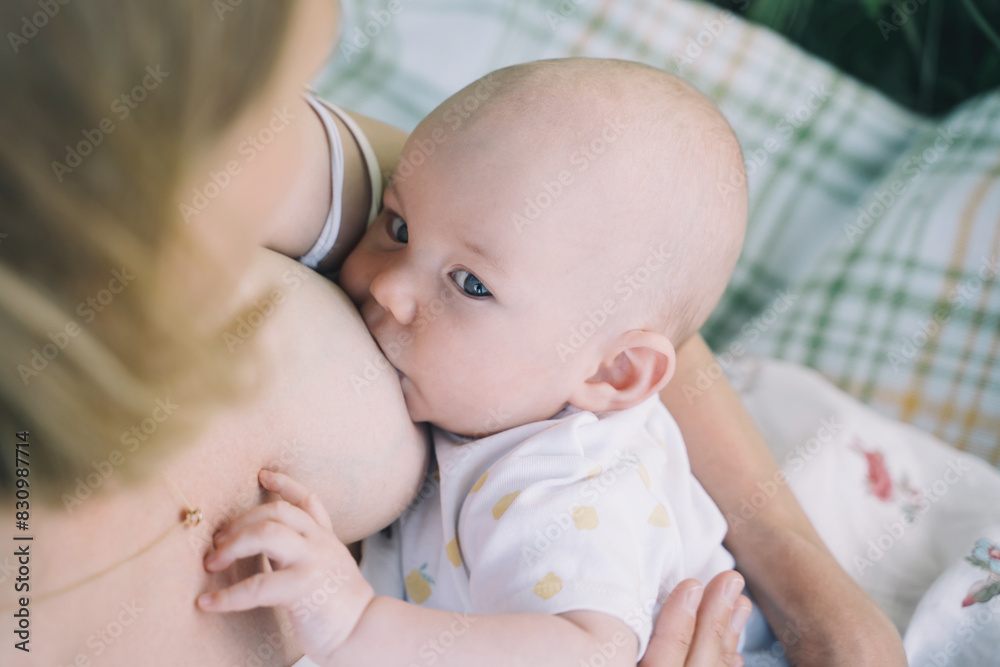 Baby eating mother's milk. Mother breastfeeding baby. Woman breast feeding her newborn baby. Concept of lactation infant, postpartum period, natural motherhood. Close-up photo Baby eating mother's milk. Mother breastfeeding baby. Woman breast feeding her newborn baby. Concept of lactation infant, postpartum period, natural motherhood. Close-up photo